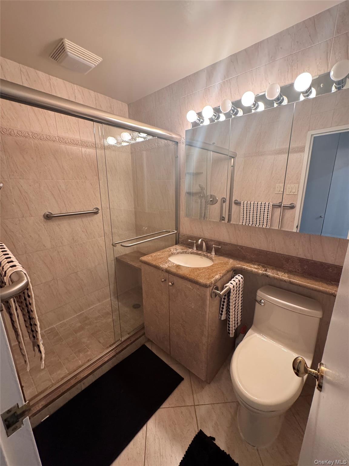 269 Grand Central Parkway, Unit 2C Queens, NY 11005 - Photo 11 of 18 Full bathroom featuring tile walls, visible vents, toilet, and a shower stall