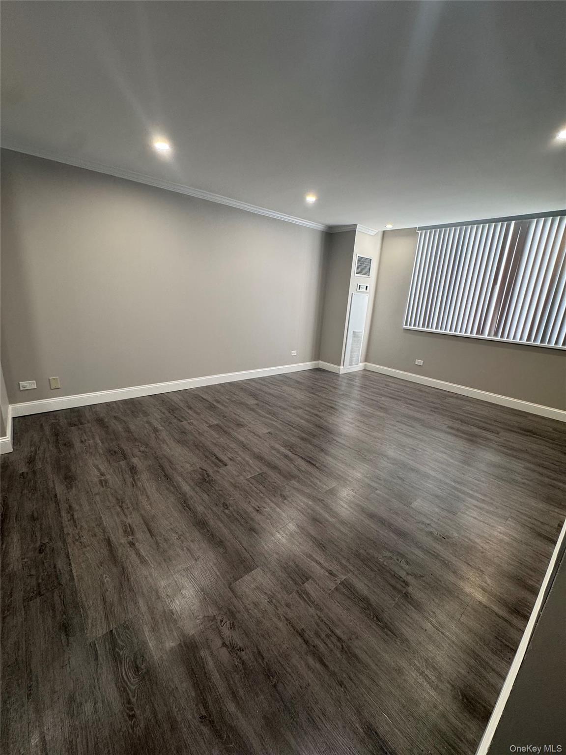 269 Grand Central Parkway, Unit 2C Queens, NY 11005 - Photo 12 of 18 Empty room with dark wood-style floors, recessed lighting, and ornamental molding