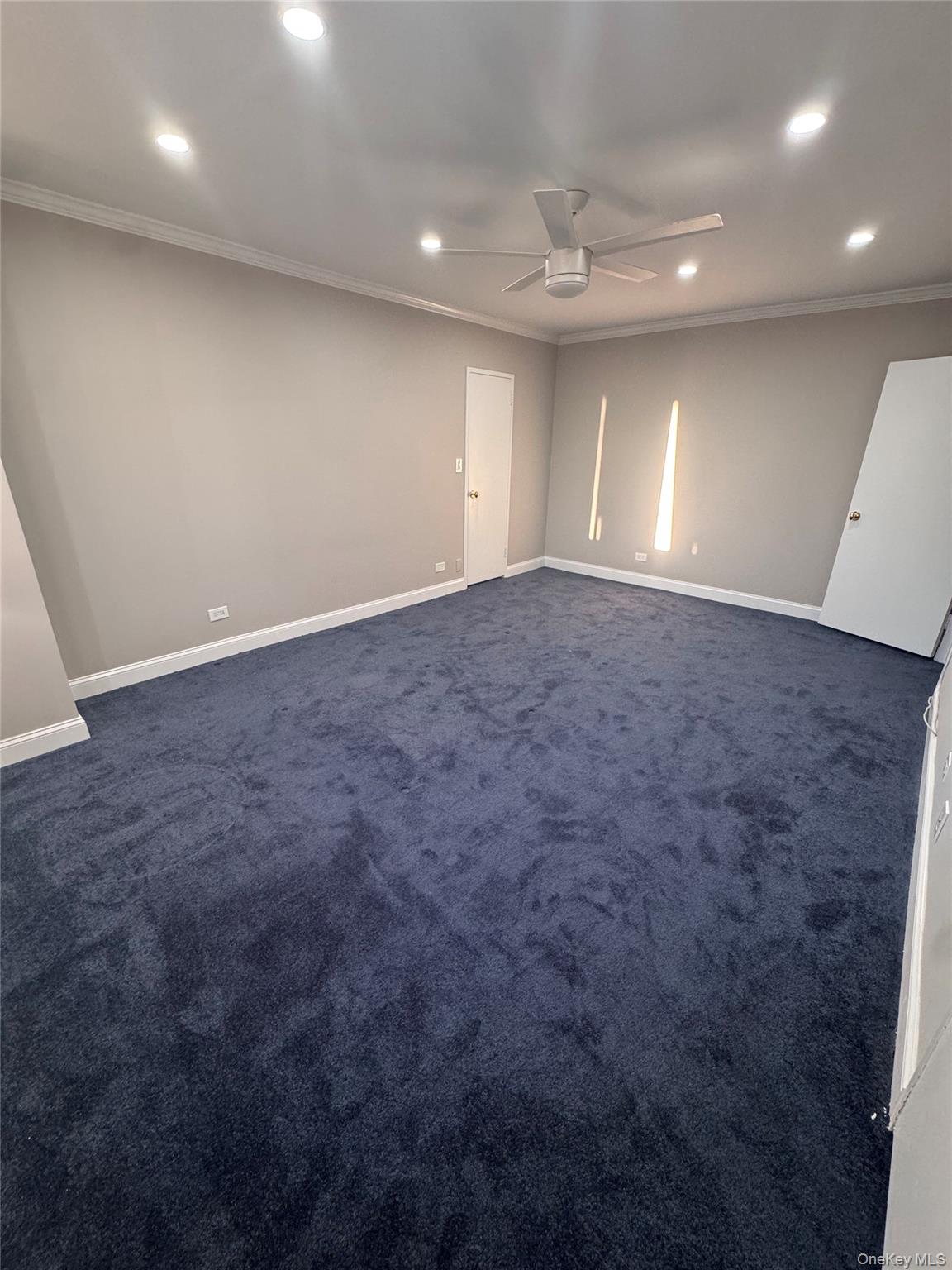 269 Grand Central Parkway, Unit 2C Queens, NY 11005 - Photo 9 of 18 Empty room with recessed lighting, ornamental molding, dark carpet, and ceiling fan