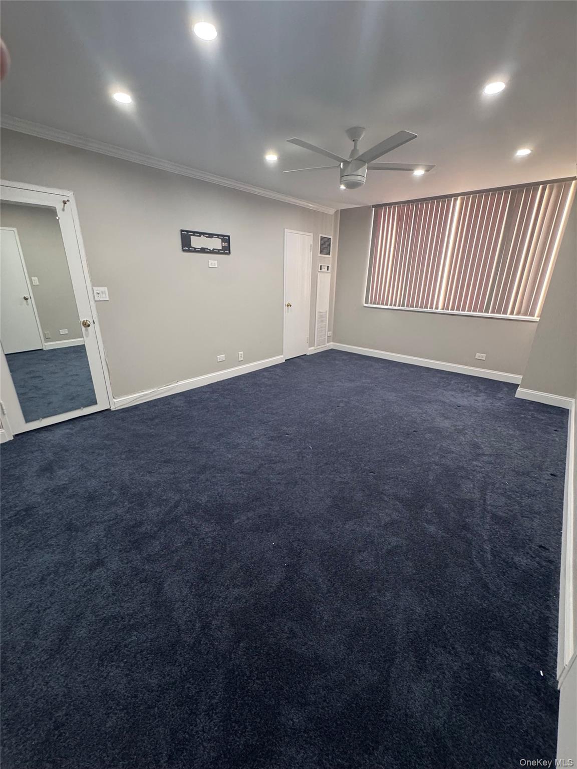 269 Grand Central Parkway, Unit 2C Queens, NY 11005 - Photo 10 of 18 Empty room with dark colored carpet, recessed lighting, ornamental molding, and ceiling fan