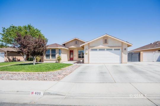 408 Acacia Street Ridgecrest, CA 93555 - Photo 1 of 32 a front view of a house with a yard and garage
