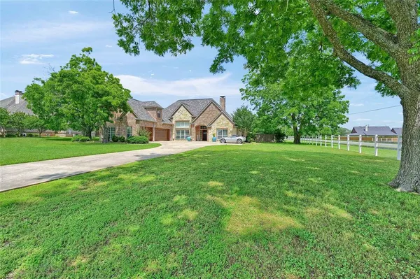 a view of a house with a big yard and large trees