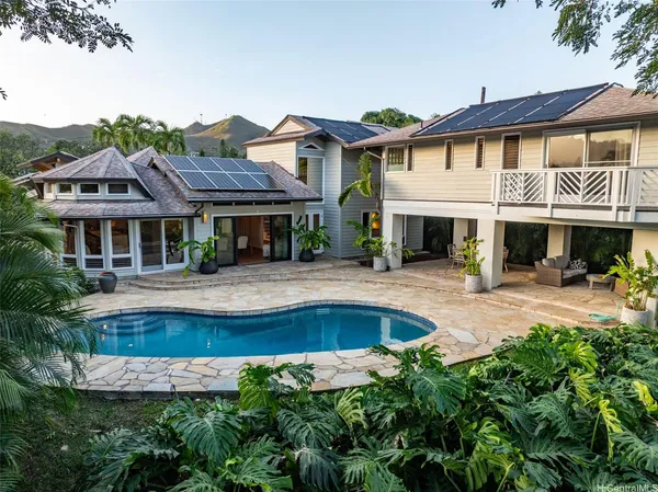 a front view of a residential houses with yard and swimming pool