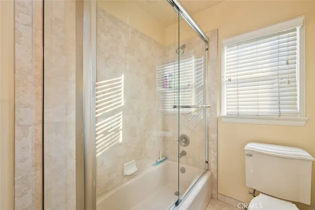 a bedroom with a bed mirror and view of balcony