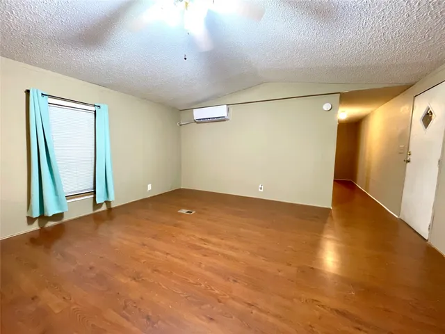 an empty room with wooden floor and entrance