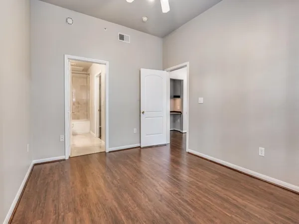 a view of an empty room with wooden floor and closet