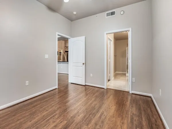 an empty room with wooden floor and closet