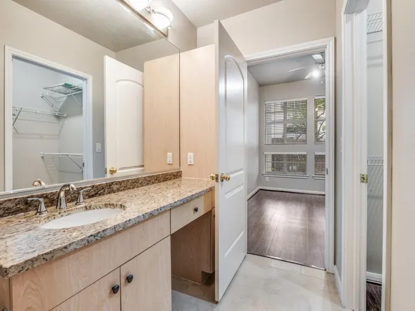 a bathroom with a granite countertop double vanity sink and mirror