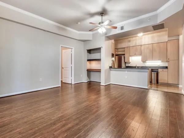 a view of a kitchen with a sink dishwasher cabinets and wooden floor
