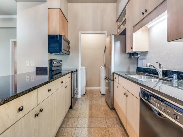 a large white kitchen with stainless steel appliances and a sink