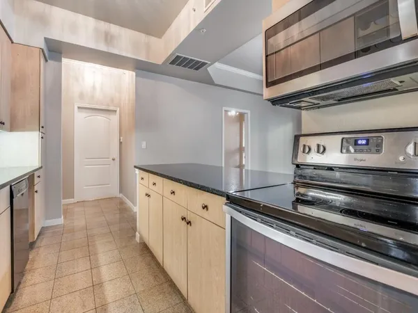 a kitchen with granite countertop a stove and cabinets