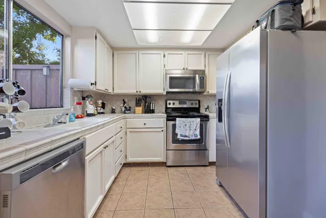 a kitchen with stainless steel appliances a refrigerator sink and microwave