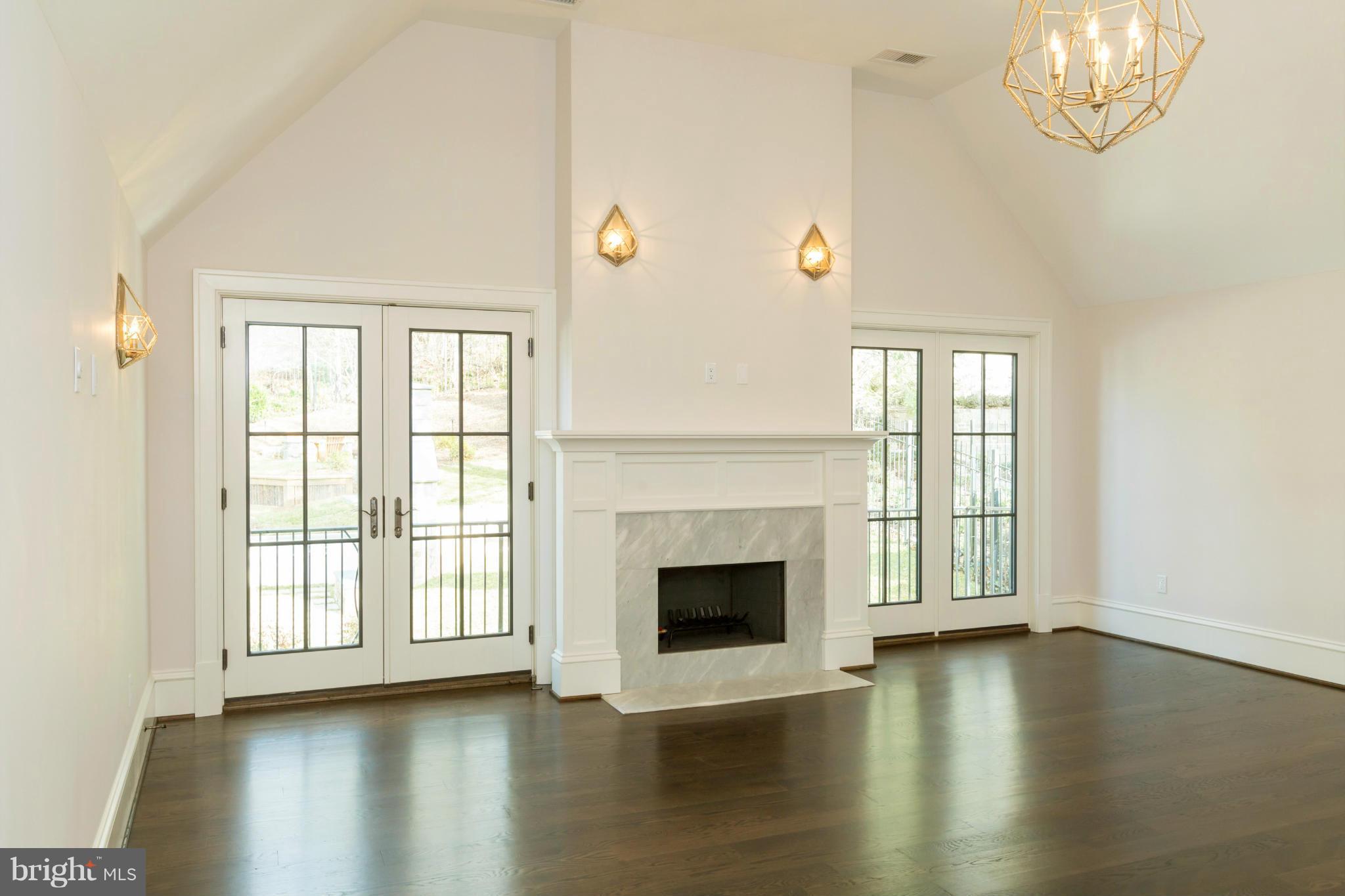 4871 Glenbrook Road Northwest Washington, DC 20016 - Photo 8 of 21 an empty room with wooden floor fireplace and windows