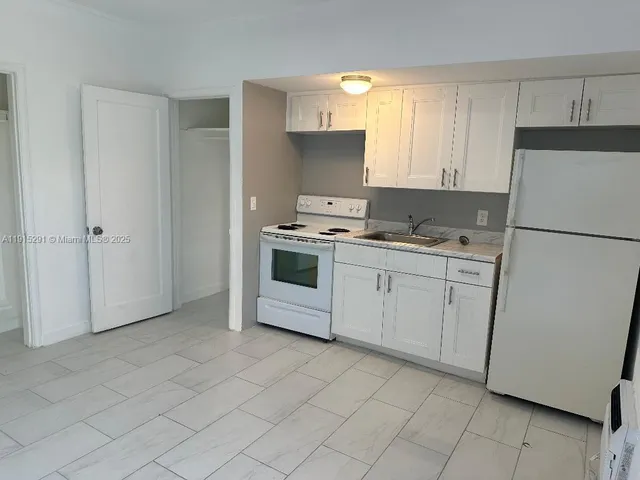 a kitchen with cabinets appliances and a sink