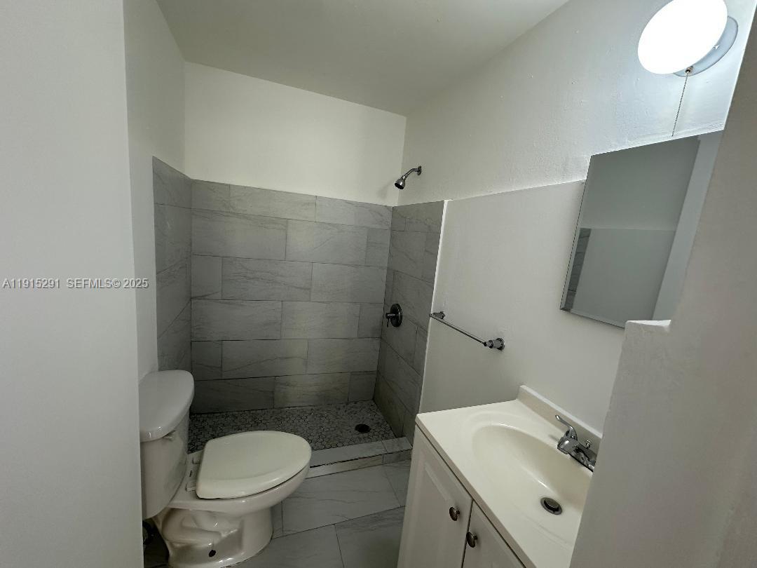 1293 Northeast 109th Street, Unit 3 Miami, FL 33161 - Photo 8 of 10 a bathroom with a sink toilet and shower