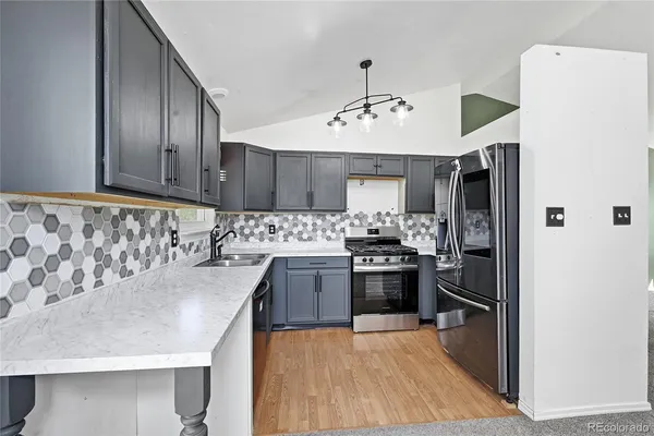 a view of kitchen with refrigerator and window