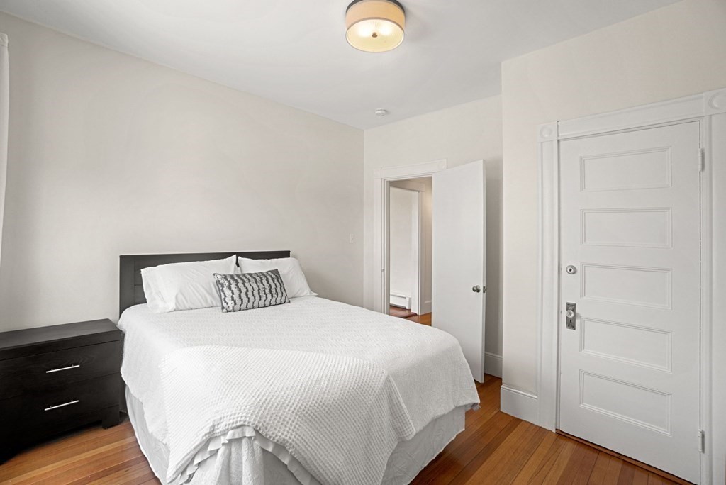 90 Robbins Road, Unit 2 Arlington, MA 02476 - Photo 18 of 32 a bedroom with a bed and wooden floor