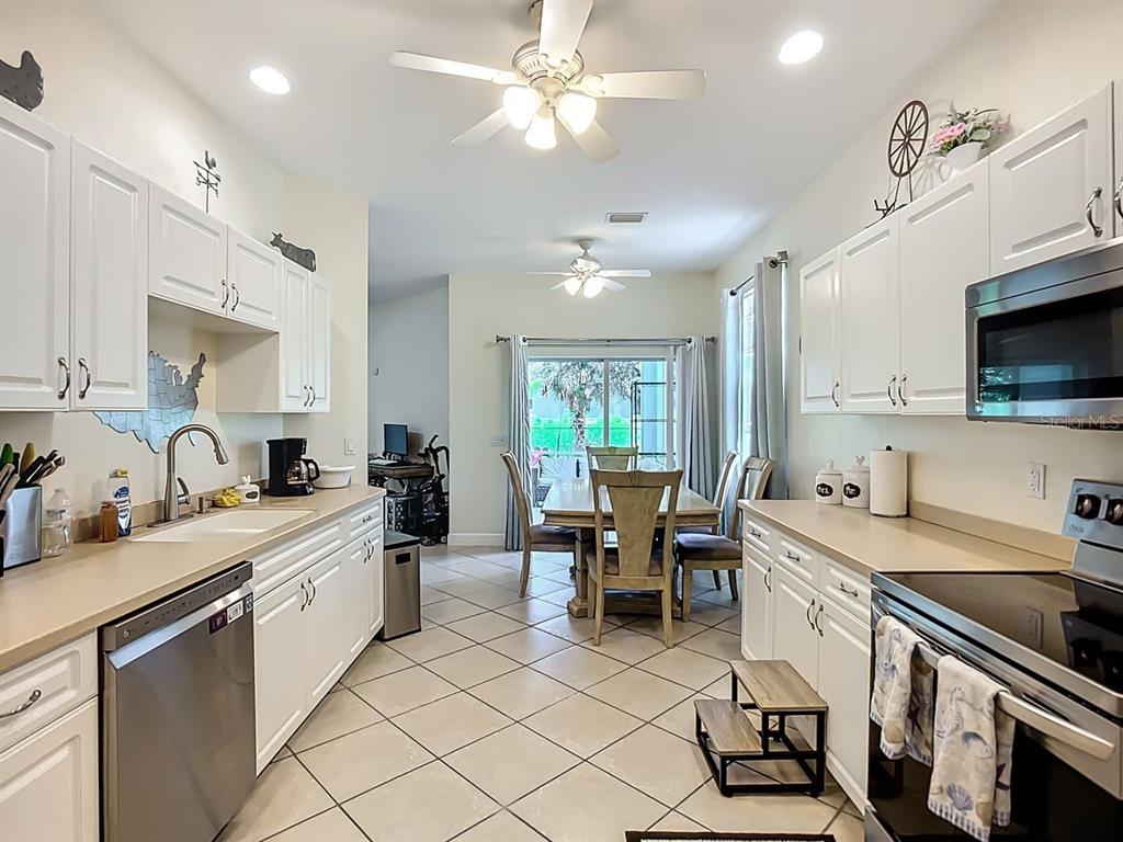 394 Sunset Road Rotonda West, FL 33947 - Photo 14 of 41 a kitchen with counter top space appliances and cabinets