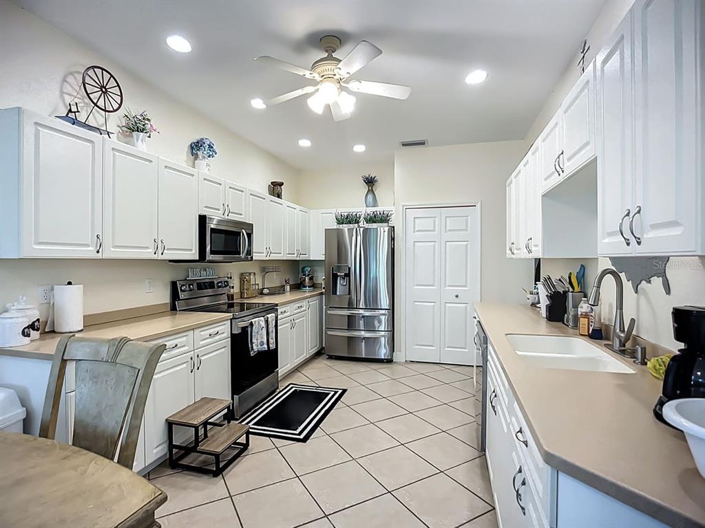 394 Sunset Road Rotonda West, FL 33947 - Photo 15 of 41 a kitchen with granite countertop a sink stainless steel appliances and cabinets