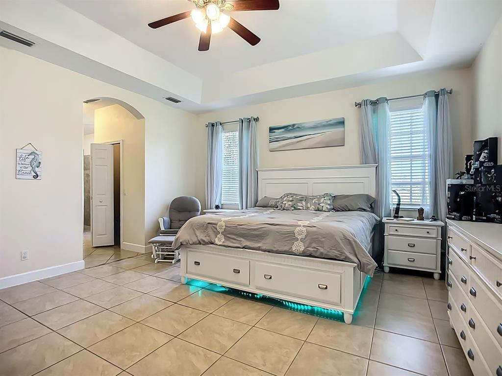 394 Sunset Road Rotonda West, FL 33947 - Photo 19 of 41 a bedroom with a bed and a chandelier