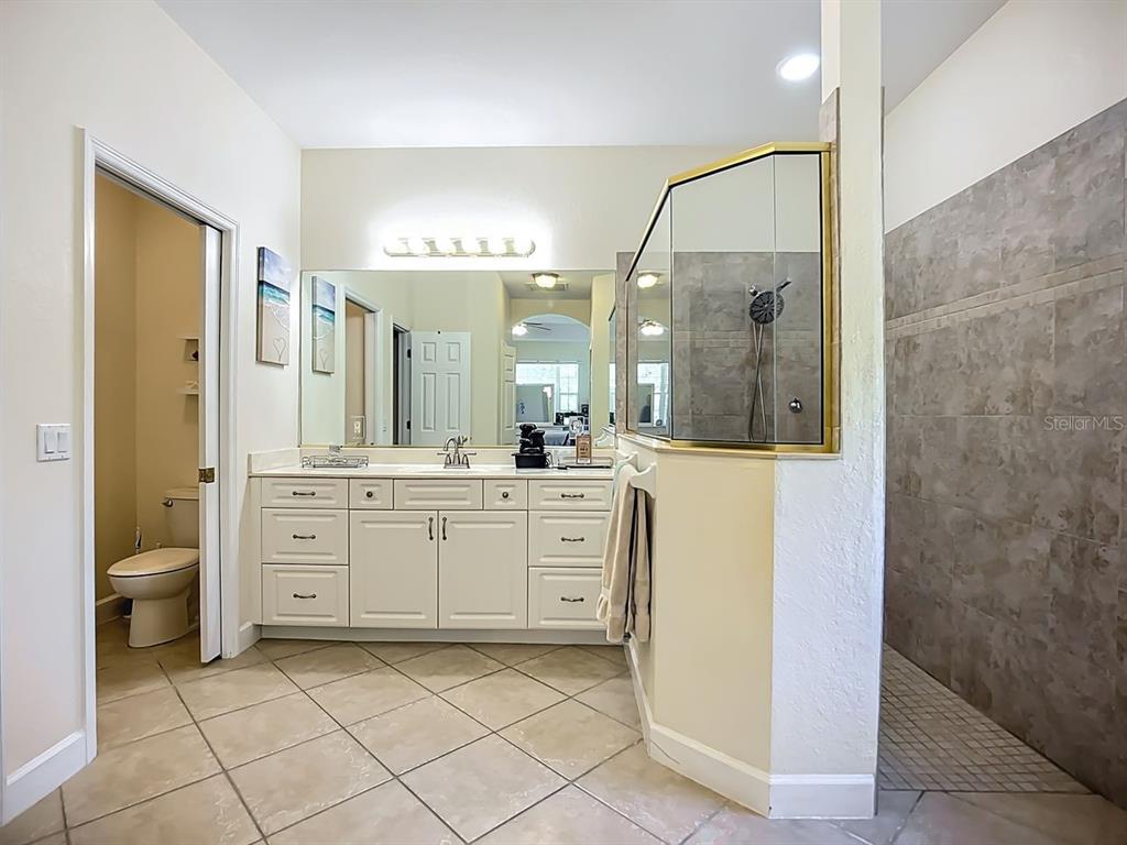 394 Sunset Road Rotonda West, FL 33947 - Photo 20 of 41 a spacious bathroom with a granite countertop sink mirror and a toilet