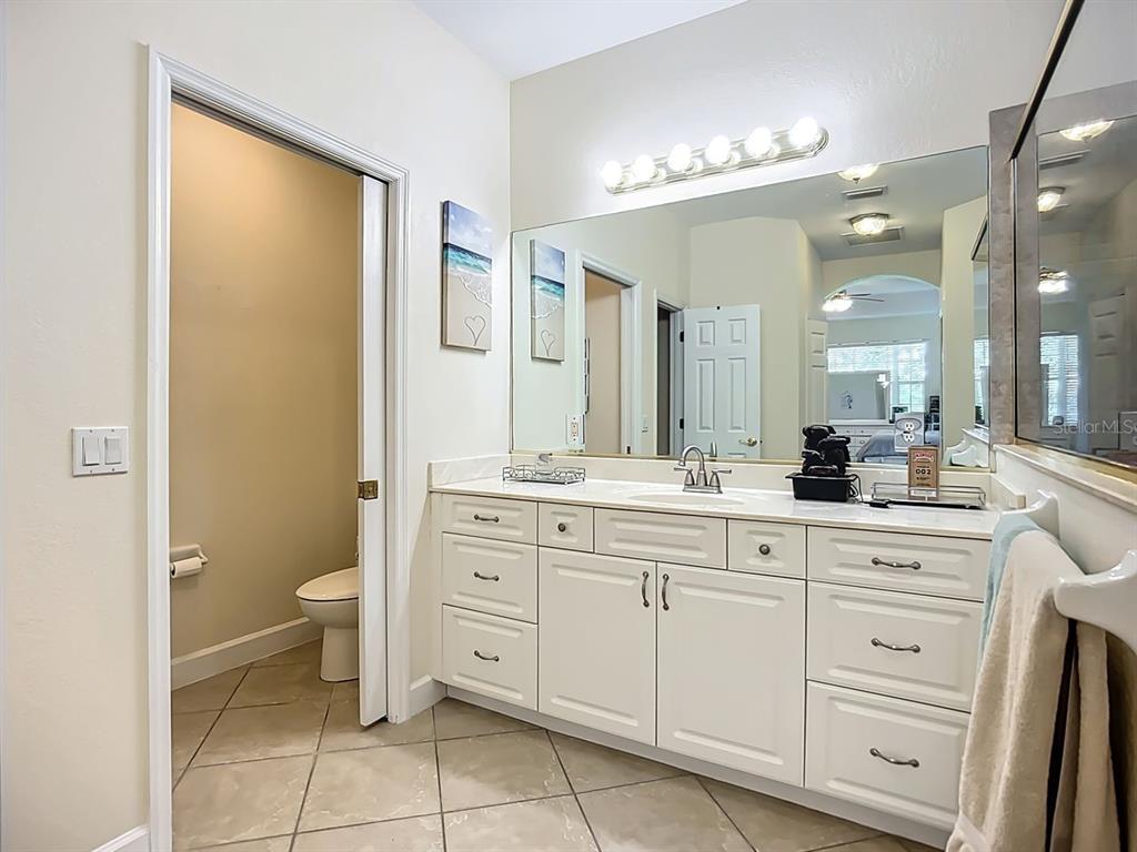 394 Sunset Road Rotonda West, FL 33947 - Photo 23 of 41 a spacious bathroom with a double vanity sink a toilet and a mirror