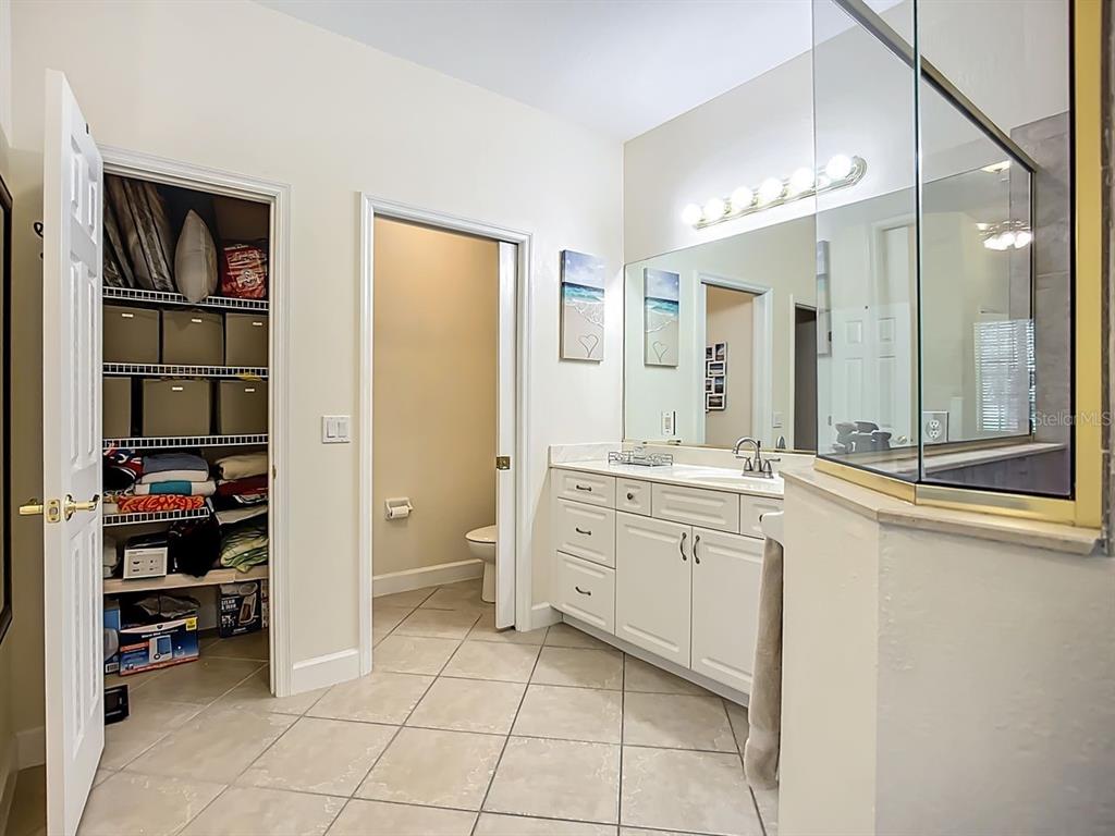 394 Sunset Road Rotonda West, FL 33947 - Photo 24 of 41 a spacious bathroom with a shower a sink and a large mirror