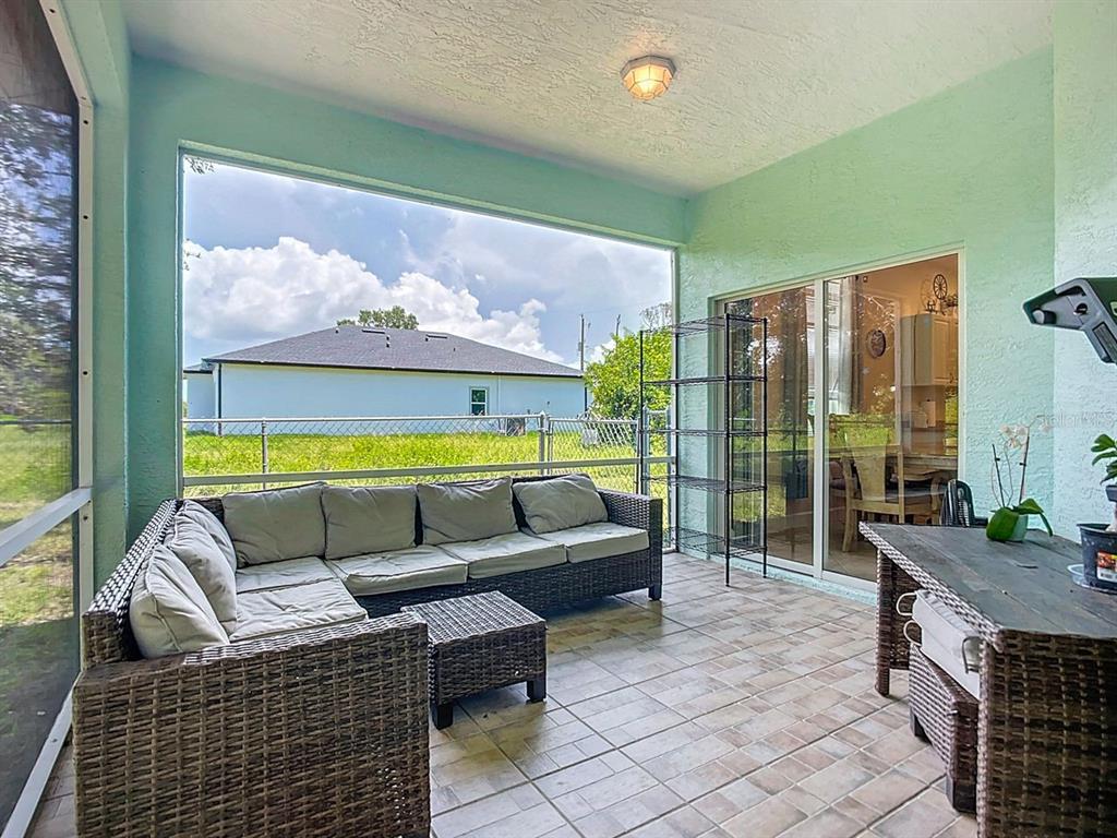 394 Sunset Road Rotonda West, FL 33947 - Photo 32 of 41 a living room with furniture floor to ceiling window and outdoor view
