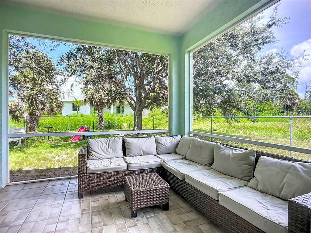 394 Sunset Road Rotonda West, FL 33947 - Photo 33 of 41 a living room with patio furniture and a garden