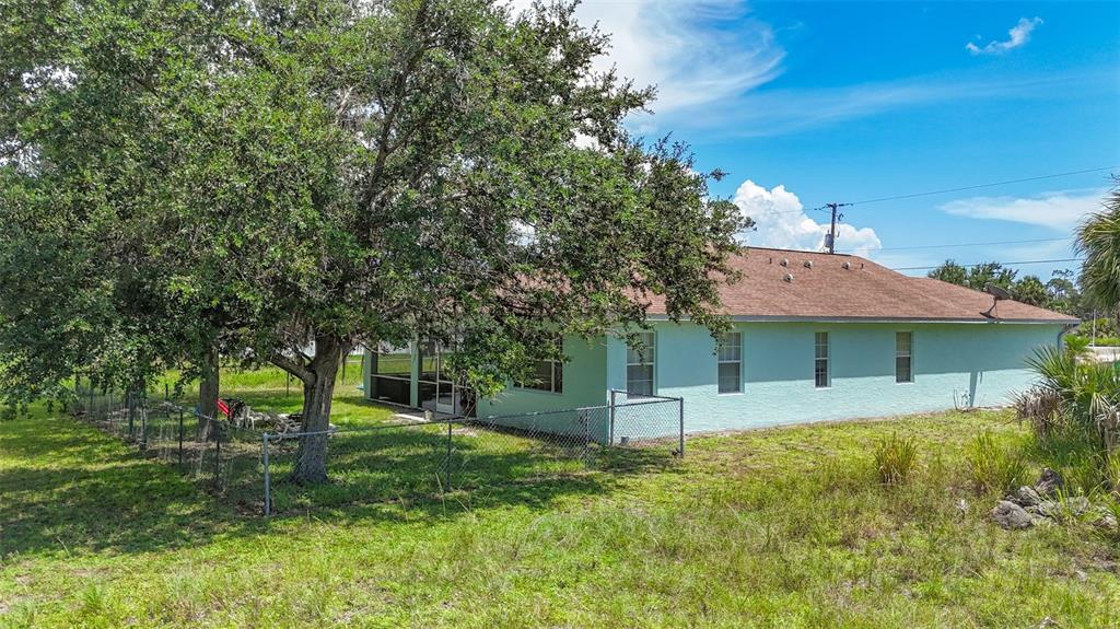 394 Sunset Road Rotonda West, FL 33947 - Photo 37 of 41 a backyard of a house with plants and large tree