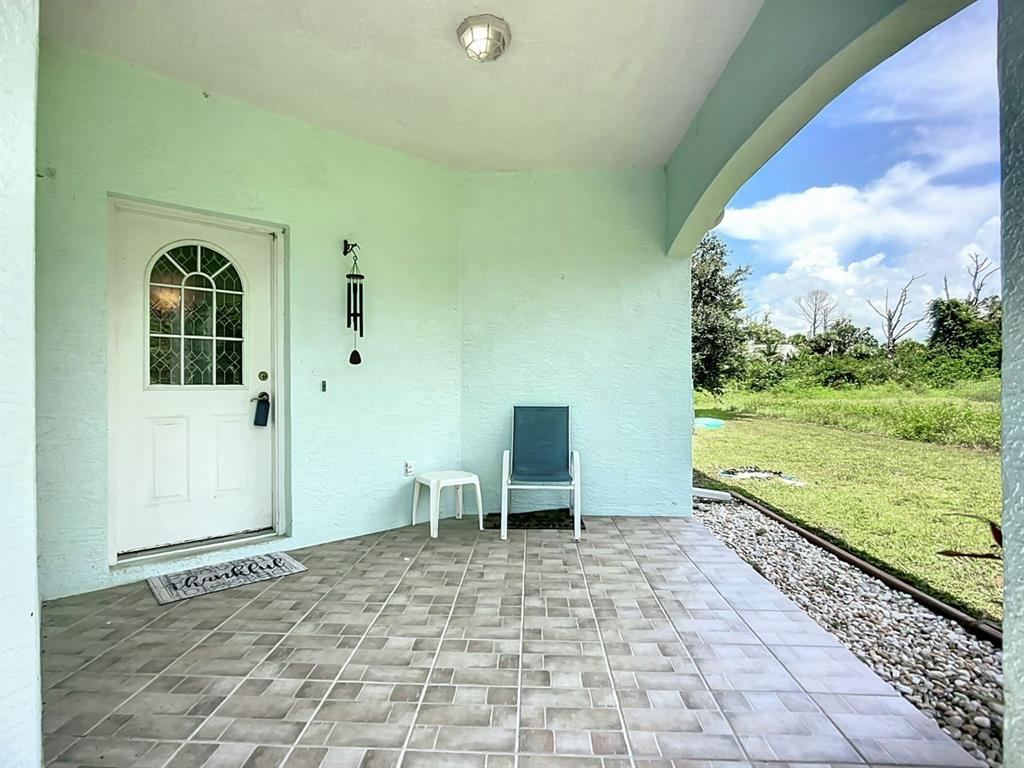 394 Sunset Road Rotonda West, FL 33947 - Photo 7 of 41 a view of an chairs and table in patio next to a yard