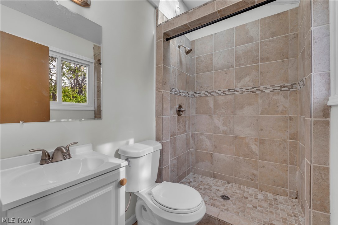 2540 Charney Road University Heights, OH 44118 - Photo 30 of 44 Shower enclosure with neutral-toned rectangular tile walls and a mosaic accent band