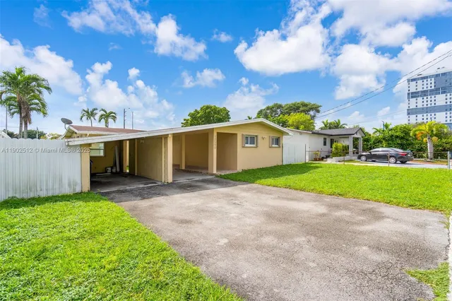 a view of a house with a yard and tree s