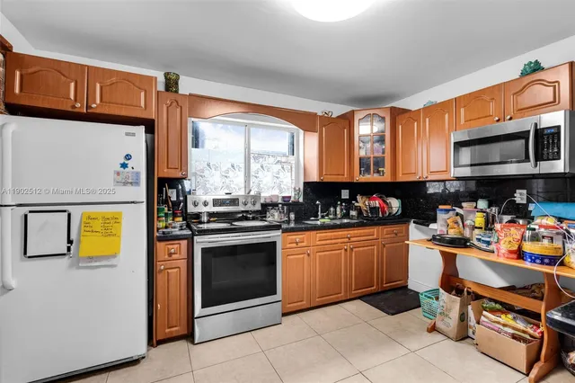 a kitchen with stainless steel appliances granite countertop a stove top oven a sink dishwasher and cabinets