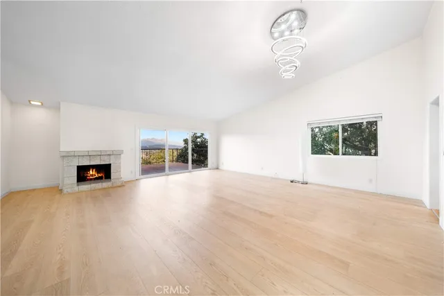 an empty room with fireplace and wooden floor