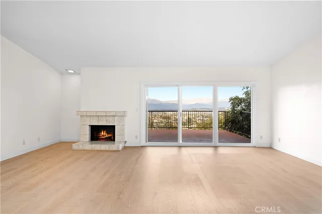 an empty room with floor to ceiling window and an outdoor view
