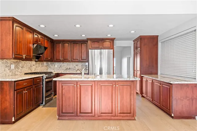 a kitchen with stainless steel appliances granite countertop wooden cabinets a stove top oven a sink and dishwasher