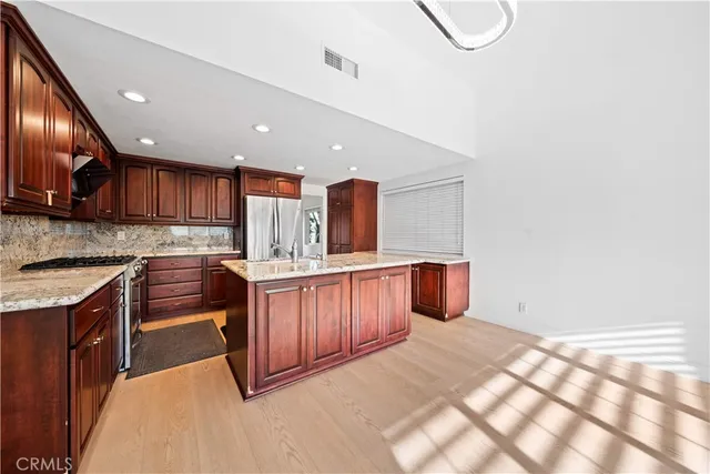 a kitchen with stainless steel appliances granite countertop a stove a sink and a microwave