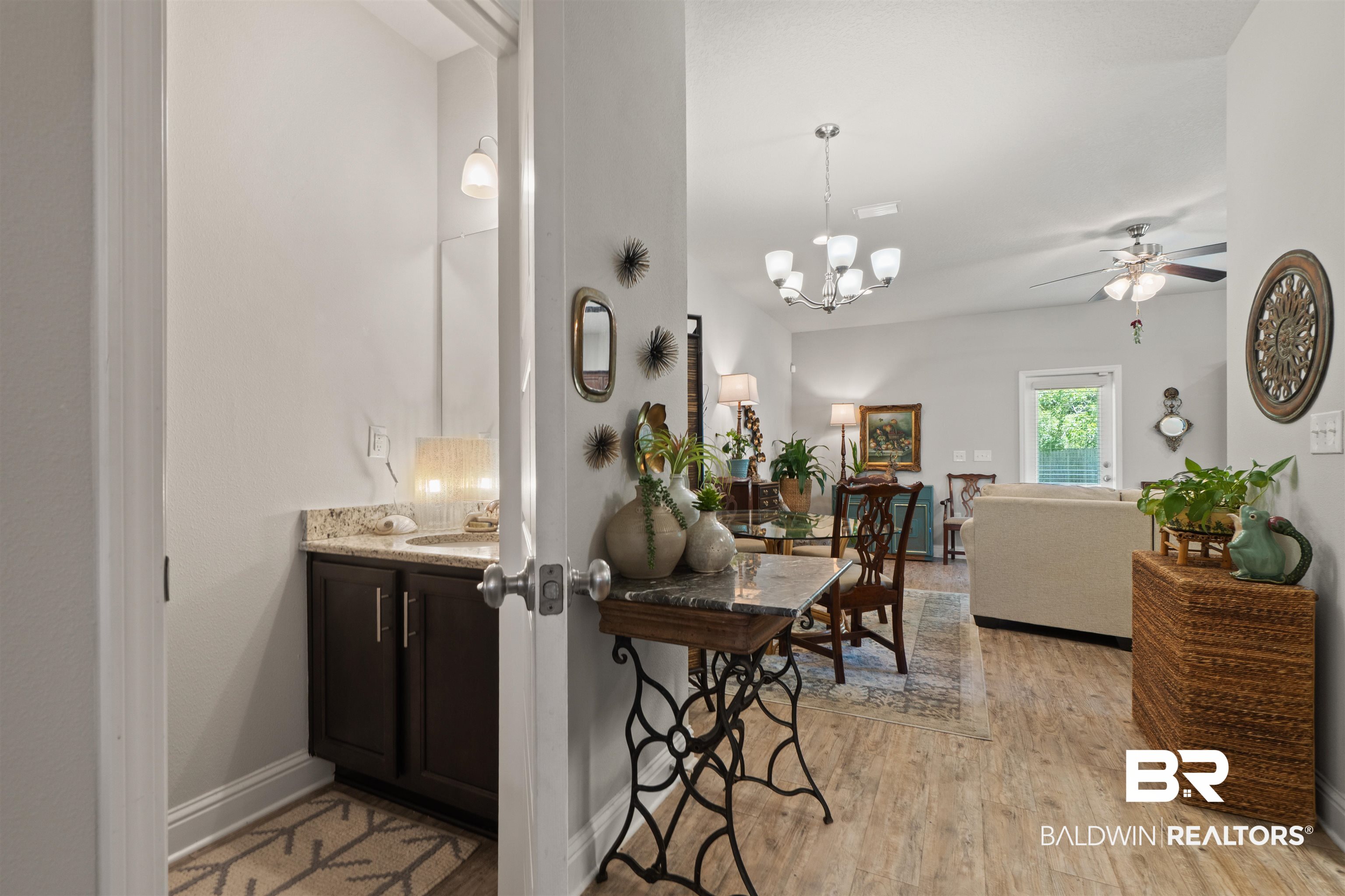 25806 Pollard Road, Unit 6 Daphne, AL 36526 - Photo 12 of 38 Open living area featuring wood-finish flooring, a contemporary chandelier, and a ceiling fan