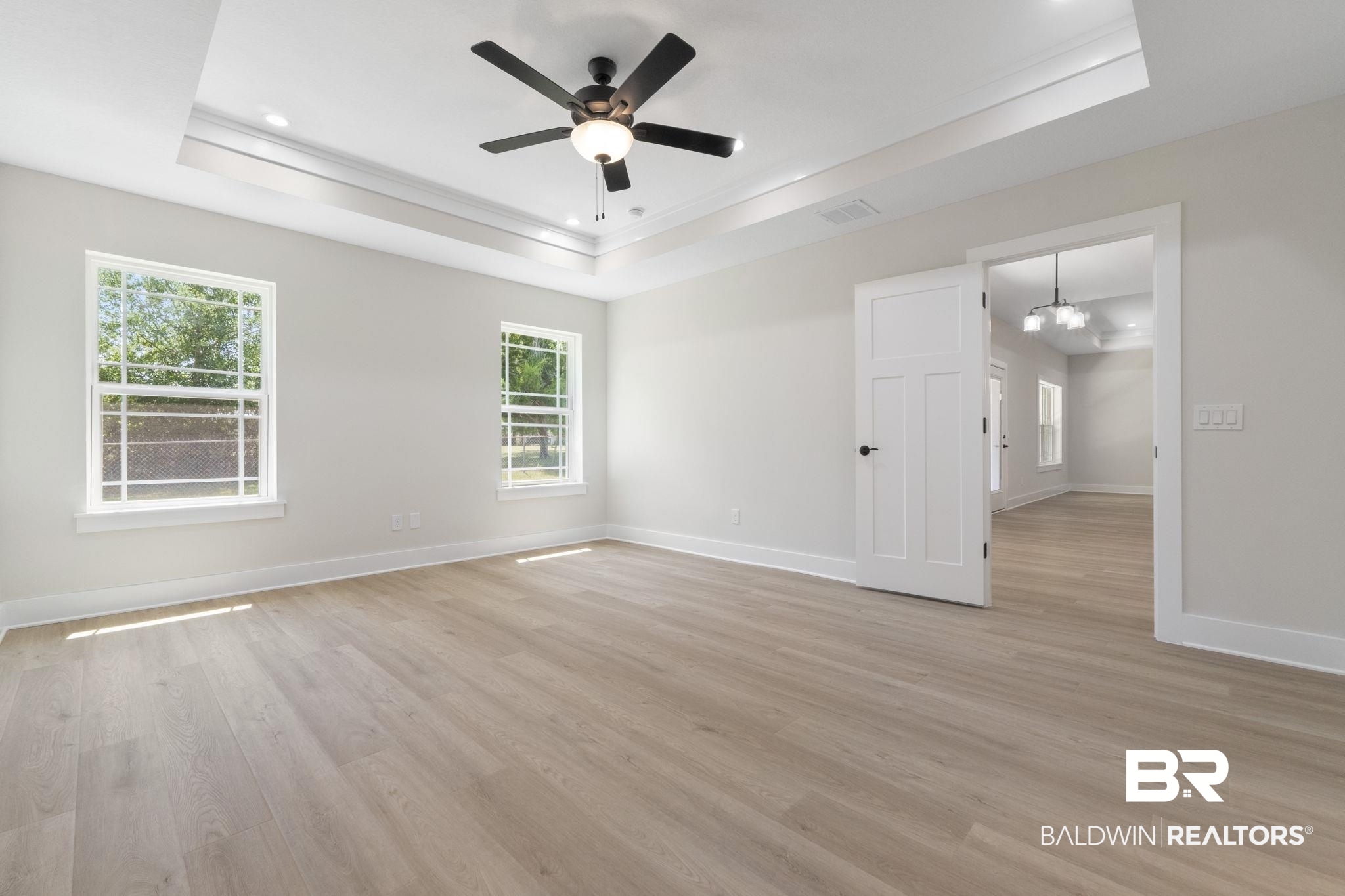 32563 Arbor Ridge Circle Lillian, AL 36549 - Photo 18 of 53 Empty room featuring a tray ceiling, light wood finished floors, a chandelier, ceiling fan, and recessed lighting
