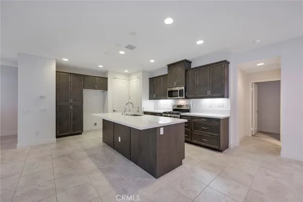 a large kitchen with a lot of cabinets and stainless steel appliances