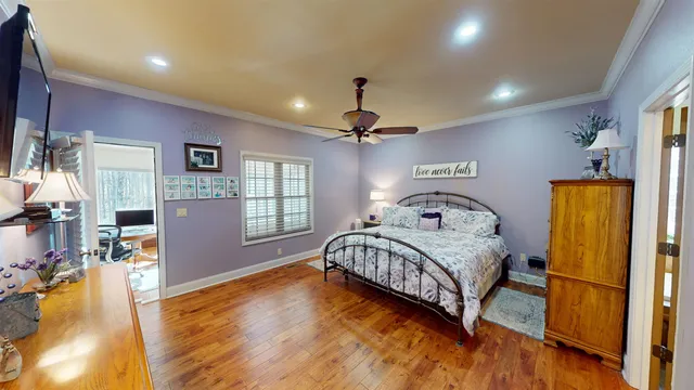 a bedroom with a bed wooden floor and window