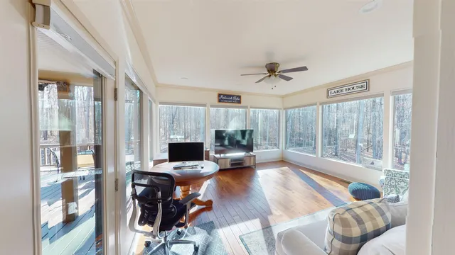 a living room with furniture floor to ceiling window and a kitchen view