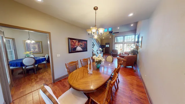 a dining room with furniture a chandelier and wooden floor
