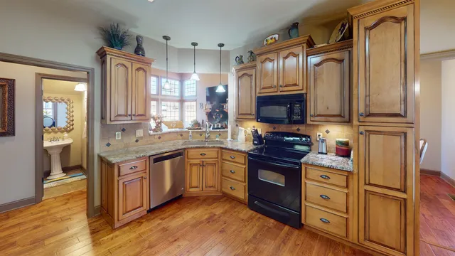 a kitchen with stainless steel appliances granite countertop a stove refrigerator and cabinets