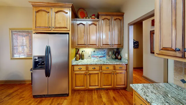 a kitchen with wooden floors cabinets and appliances