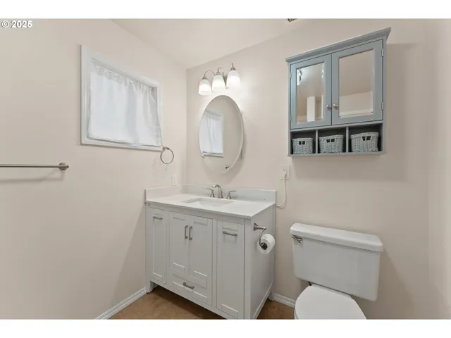 a bathroom with a sink a toilet and a mirror