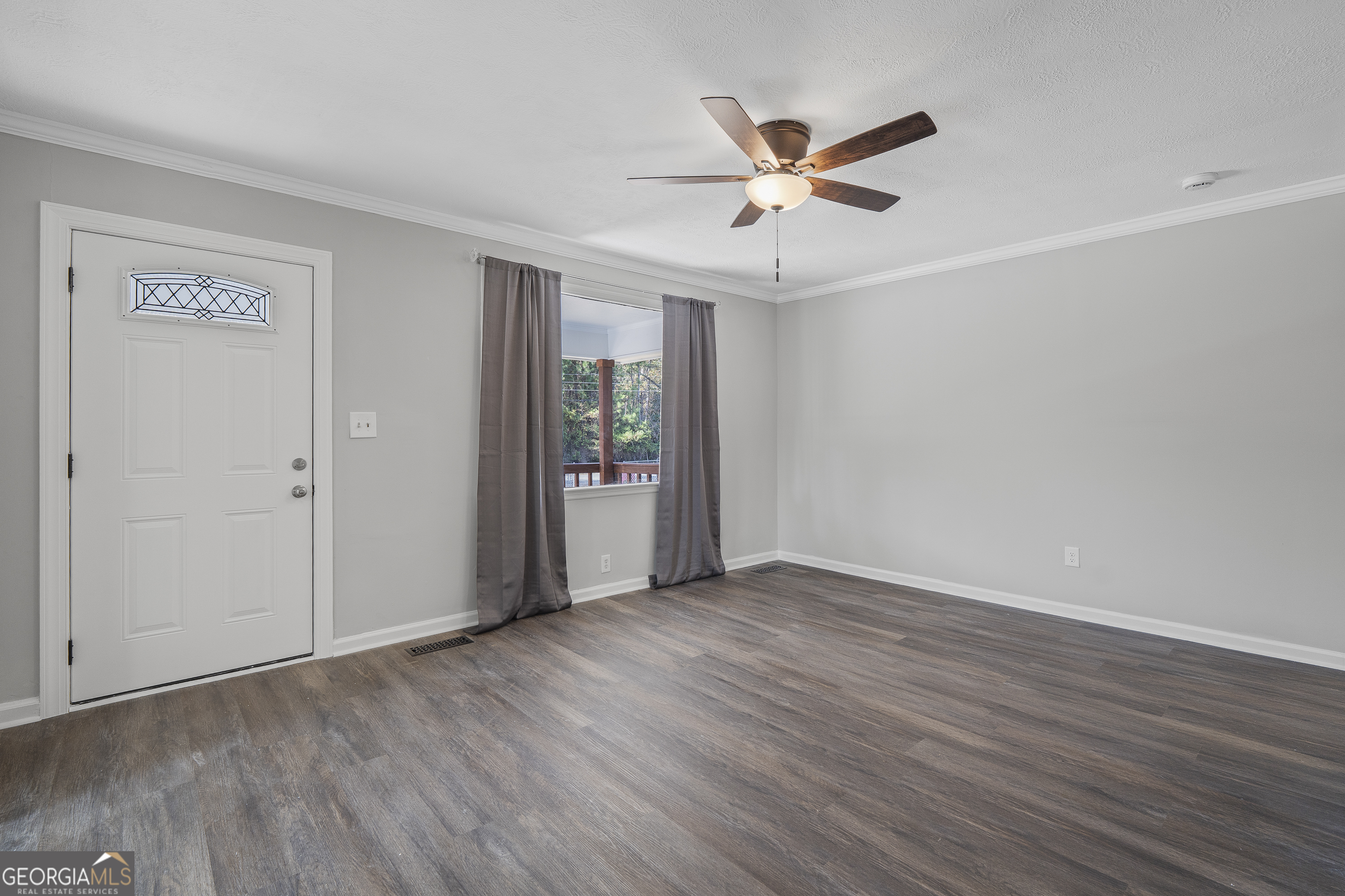 4622 Wilson Road Macon, GA 31206 - Photo 6 of 24 an empty room with wooden floor fan and windows