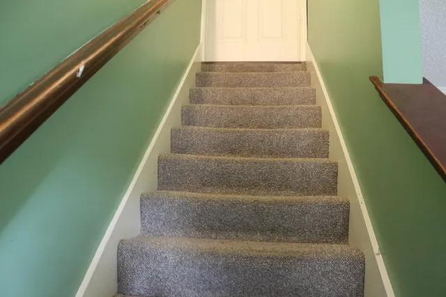 a view of staircase with white walls and a window
