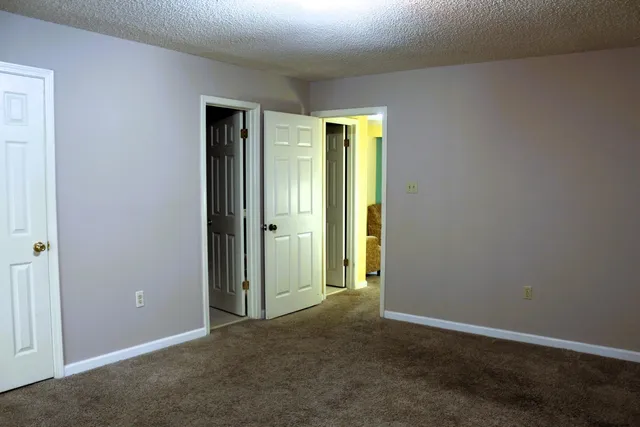 an empty room with closet and a bathroom